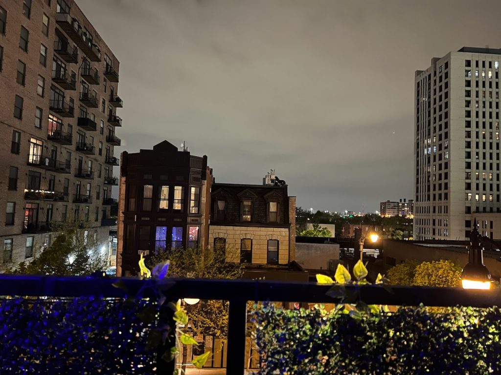 Condo balcony with planters overlooking Wabash Avenue in the evening
